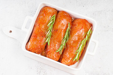 Marinated Chicken Breast with spices and rosemary. Raw meat in the marinade. Sottilissime raw fillet with spices and rosemary for grilling top view