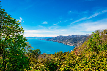 Fototapeta na wymiar Springtime view of the Ligurian Sea shoreline, from the top of Portofino Mountain; on background, the cities of Camogli, Recco and Sori (Genoa Province).