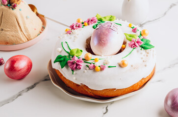 Tradition Easter kulich cake on a plate over white mrble table.