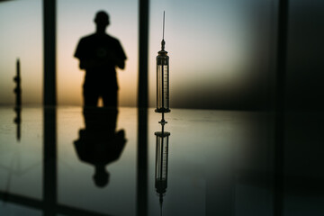 syringe with medicine on a background of sun light. concept of a new vaccine.