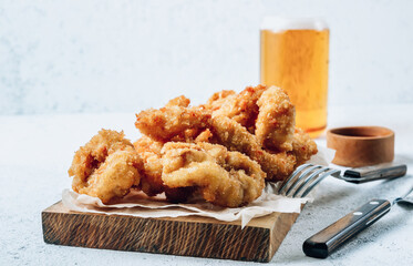Breaded rings of squid with lemon on a white background. Snack to beer.