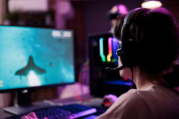 Happy woman streaming online multiplayer video games play on computer, enjoying shooting gameplay tournament. Female streamer playing action rpg game competition on pc monitor.
