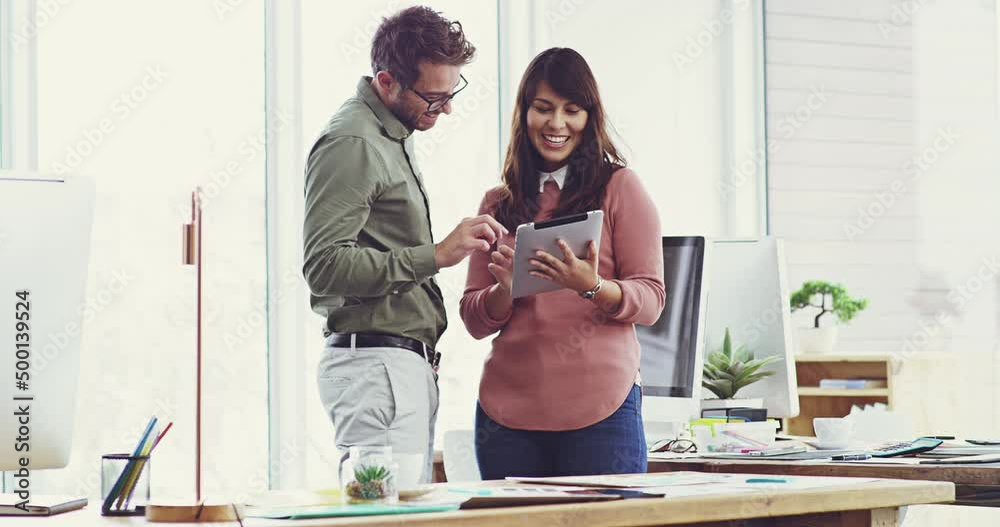 Poster i think thats a brilliant idea.two cheerful young work colleagues standing talking while using a tab