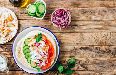 Healthy diet Gyros, greek pita bread wrapped sandwich with meat slices, tzatziki and fresh vegetables.
