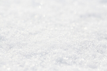 White snow close-up. Winter background with snow texture. Shallow depth of field and blur. Perfect for Christmas and New Year design. View with copy space.