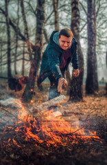 a man lights a bonfire in the woods