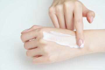 手にクリームを塗る女性
