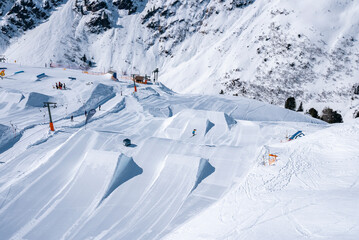 Snowpark and scenic view of skilift and drag lift on snow covered landscape. Winter sports at...