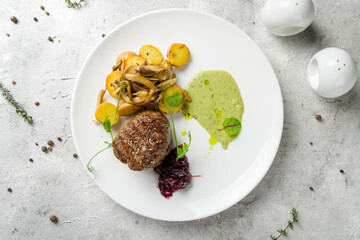 grilled steak filet Mignon with fried baby potatoes and onion jam on white plate top view