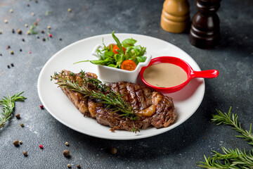 juicy Ribeye steak with pepper sauce on white plate