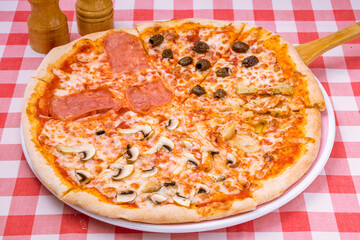 Pizza four seasons on plate on red italian table