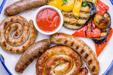 assorted sausages with sauces and grilled vegetables top view macro close up