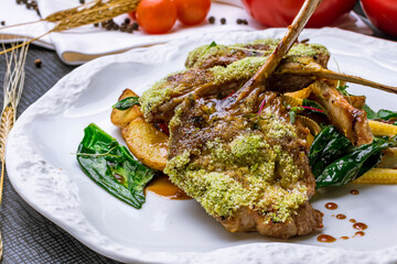 Rack of lamb with potatoes and spinach on white plate macro close up