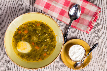 Sorrel soup with egg on old wooden table top view