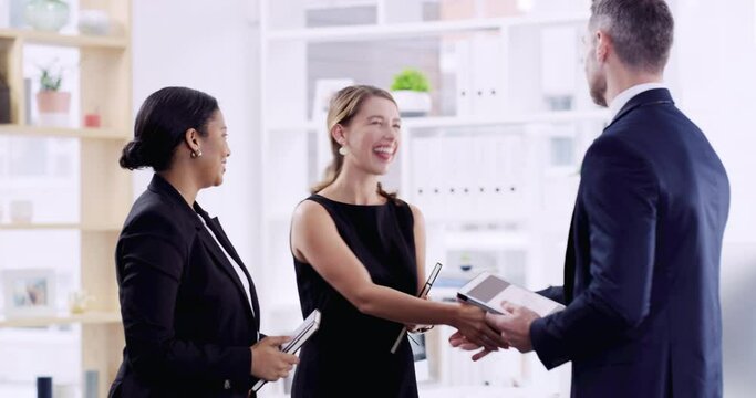 And with that, the merger is complete. Three well dressed businesspeople shaking hands in a corporate office. Businesspeople looking positive while making a deal. Diverse professionals in agreement 