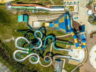 Aerial top down view of a deserted curving  and swirling waterslide with empty pool next to a tornedo ride in an American amusement park