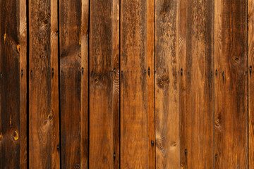 Wodden brown planks in various shades of colours, aged wodden wall of the cottage house surface making a good background material