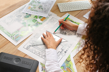 Young female landscape designer working in office