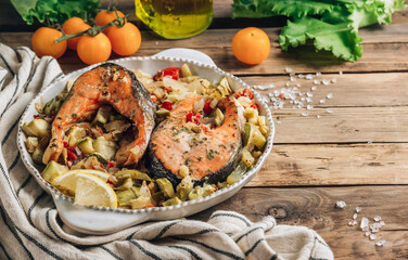 Baked salmon steak with veggies over wooden rustic background. Healthy food concept.