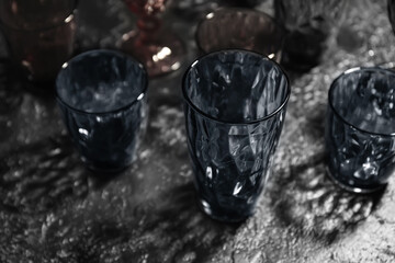 Different empty glasses on dark background