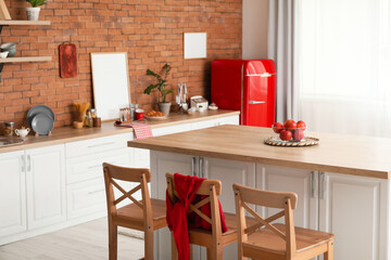 Interior of modern kitchen with dining table, counter and stylish refrigerator