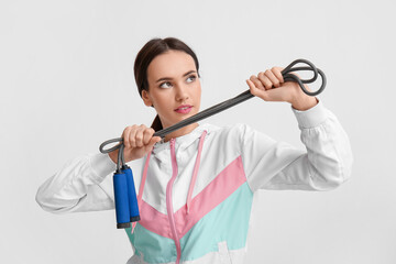 Sporty young woman with skipping rope on white background. Immunity concept - obrazy, fototapety, plakaty