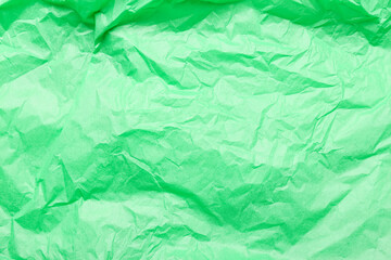 Texture of green crumpled paper as background, closeup