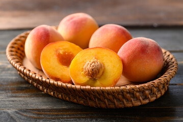 Peach fruit in basket on wooden background