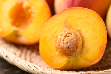 Naklejka na ściany i meble Peach fruit in basket on wooden background, Close up