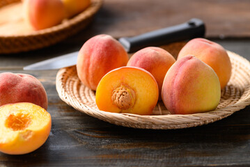 Peach fruit in basket on wooden background