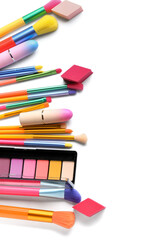 Different cosmetics and makeup brushes isolated on white