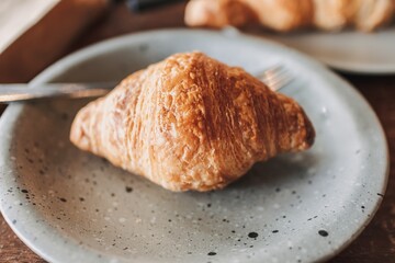 Close up of homemade croissant served on wooden table