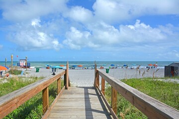 View of beach from wooden boardwalk over the dunes in Cocoa Beach, Florida near Cape Canaveral. 