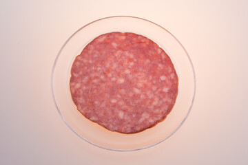 Thin salami slice directly above ,in a transparent  dish