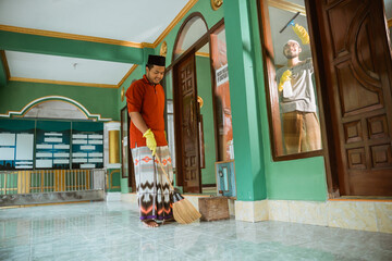 portrait of asian muslim young male cleaning the mosque before praying