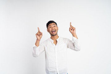 excited asian young man with two fingers pointing up on isolated background