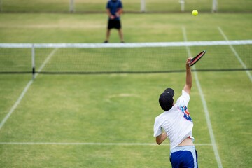 Amateur playing tennis at a tournament and match on grass in Melbourne, Australia