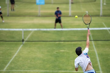 Amateur playing tennis at a tournament and match on grass in Melbourne, Australia