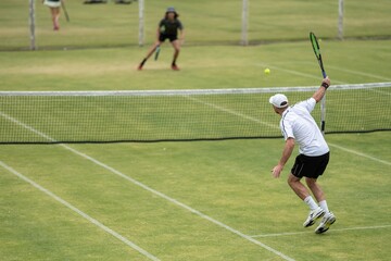 Amateur playing tennis at a tournament and match on grass in Melbourne, Australia 