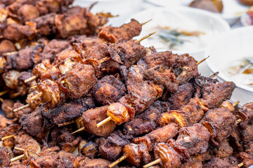 Grilled chicken sticks on a street food market close up