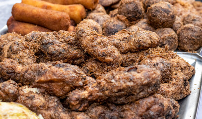 Selective focused delicious fried cookies and grilled chicken meat close up shot on a street market