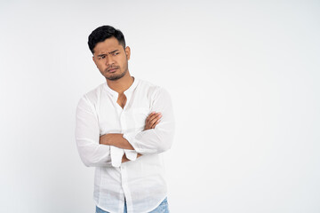 sad man wearing white shirt with arms crossed on isolated background