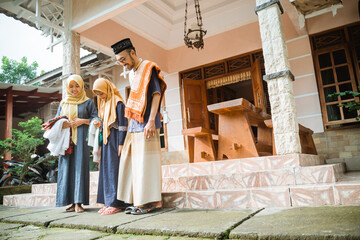 happy parent and daughter going to the mosque or a field to do idul fitri or eid mubarak prayer