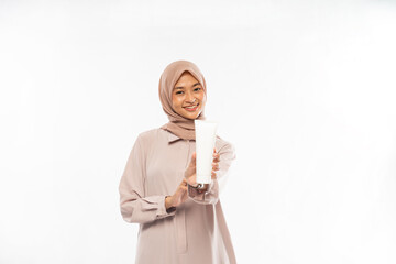 Muslim asian Beauty portrait. A beautiful girl with clean skin holds a white template tube in her...