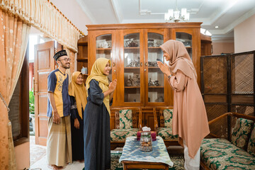 muslim woman welcoming guest's at home during idul fitri celebration