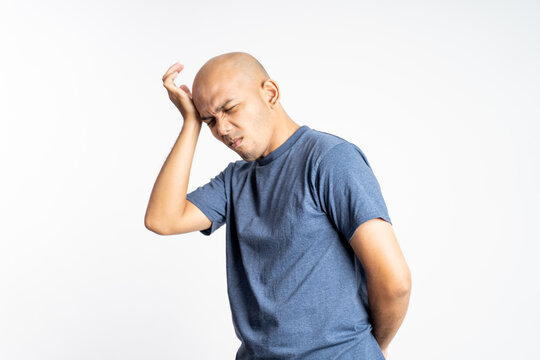 sad bald man holding his bald head on isolated background