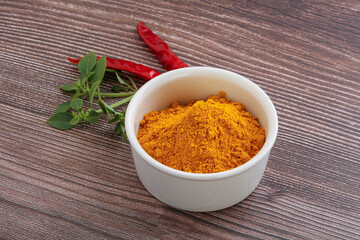 Yellow vibrant curcuma powder in the bowl