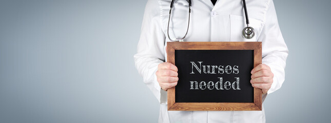 Nurses needed. Doctor shows term on a wooden sign.