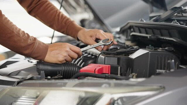 Photo of car mechanic repairs a car engine in his repair shop