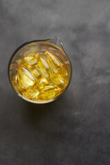 Capsules of omega-3 fatty acids on a gray background. The concept of medicine and a healthy lifestyle. Front view.